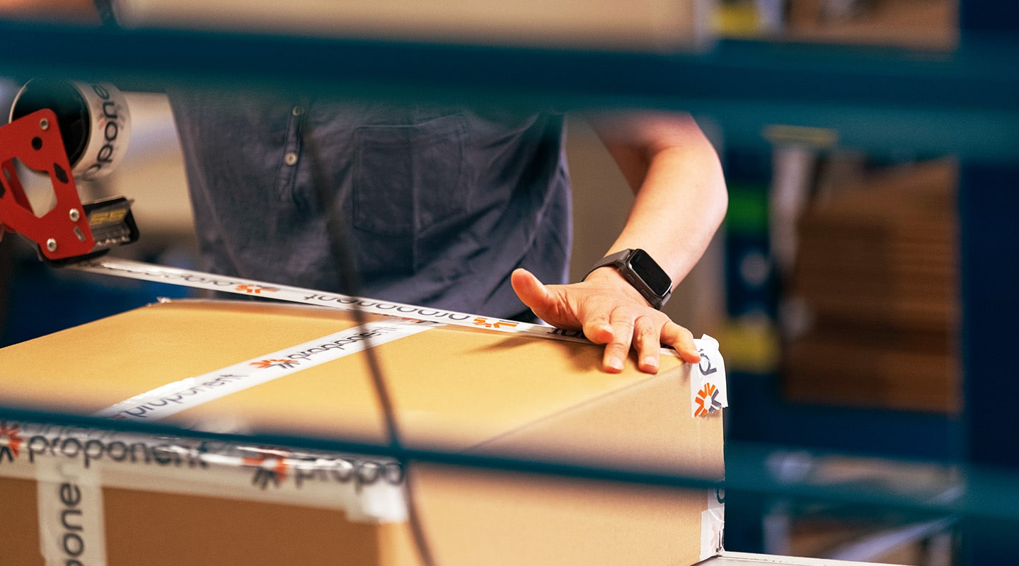 An employee taping a box shut for shipping